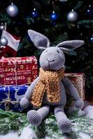 knitted elk. cute moose. toy against the background of a New Year's garland, knitted hare and elk on a Christmas tree photo