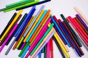 A set of multi-colored felt-tip pens in a row, rainbow on a light white banner background. Drawing markers, pencils, ink, artist tools, creativity, leisure, hobby. Colorful school supplies. photo