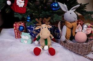 knitted elk. cute moose. toy against the background of a New Year's garland, knitted hare and elk on a Christmas tree photo