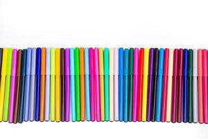 A set of multi-colored felt-tip pens in a row, rainbow on a light white banner background. Drawing markers, pencils, ink, artist tools, creativity, leisure, hobby. Colorful school supplies. photo