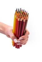 lápices multicolores para dibujar en una mano femenina. lápices multicolores en mano femenina sobre fondo blanco, primer plano, espacio de copia, arte moderno. diseño moderno foto