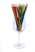 multi-colored pencils in a wine glass and a bucket. Selective blurred a group of coloring pencils in a wine glass on the isolated white or black background , Modern art. Modern photo