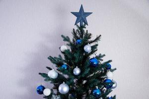 árbol de navidad con bolas de colores y cajas de regalo sobre una pared de ladrillo blanco con bolas azules y blancas foto