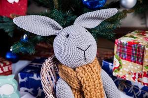 knitted elk. cute moose. toy against the background of a New Year's garland, knitted hare and elk on a Christmas tree photo