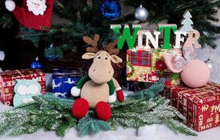 knitted elk. cute moose. toy against the background of a New Year's garland, knitted hare and elk on a Christmas tree photo