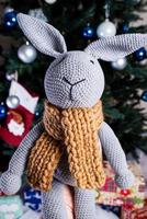 knitted elk. cute moose. toy against the background of a New Year's garland, knitted hare and elk on a Christmas tree photo