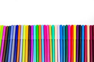 A set of multi-colored felt-tip pens in a row, rainbow on a light white banner background. Drawing markers, pencils, ink, artist tools, creativity, leisure, hobby. Colorful school supplies. photo