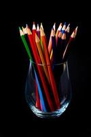 multi-colored pencils in a wine glass and a bucket. Selective blurred a group of coloring pencils in a wine glass on the isolated white or black background , Modern art. Modern photo