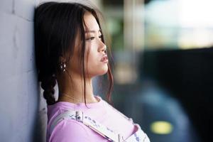 Asian woman leaning on wall photo