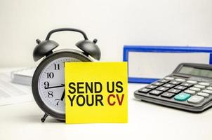 send us your cv words on yellow sticker with calculator, clock and paper folder photo