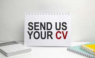 send us your cv words on paper notebook with office supplies photo