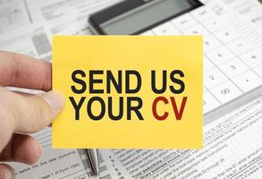 send us your cv. Text on yellow sticker with calculator photo