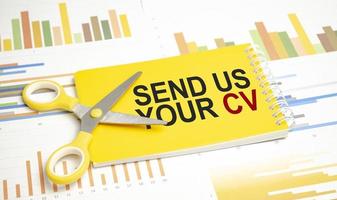 send us your cv. Text on yellow notebook and charts photo