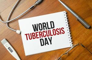 palabras del día mundial de la tuberculosis en el cuaderno y el estetoscopio sobre fondo marrón