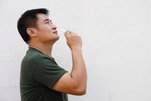 Asian man uses inhaler to smell  for relieve dizzy and faint symptoms. Concept , health problem, sickness and remedy. Increases freshness, reduces dizziness and stuffy nose. self take care. photo