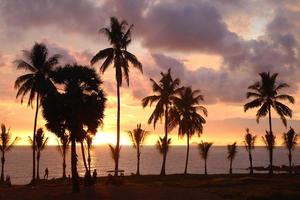 Travel to island Koh Lanta, Thailand. Palms tree on the background of the colorful sunset and cloudy sky. photo