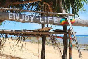 Koh Lanta, Thailand. An inscription - Enjoy life - on the wooden abandoned hut. photo