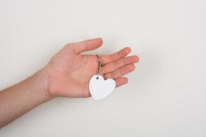 Heart shaped white object in hand on white photo