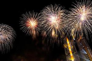 New year celebrate,  crowd and colorful fireworks near the river, Thailand photo