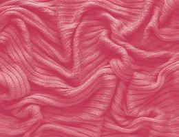Texture of smooth knitted sweater with pattern. Handmade knitting wool or cotton fabric texture. Background of Large knit pattern with knitting needle or crochet. Color Of The Year 2023 - Viva Magenta photo