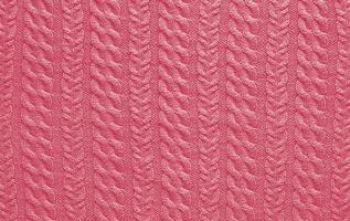 Texture of smooth knitted sweater with pattern. Handmade knitting wool or cotton fabric texture. Background of Large knit pattern with knitting needle or crochet. Color Of The Year 2023 - Viva Magenta photo