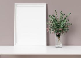 Empty vertical picture frame standing on white shelf. Frame mock up. Copy space for picture, poster. Template for your artwork. Close up view. Eucalyptus plant in vase. 3D rendering. photo