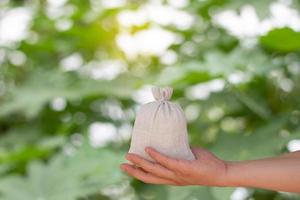 una mano que sostiene la bolsa de dinero desenfoque de fondo bokeh foto