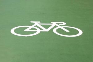 un símbolo de bicicleta en el suelo verde. foto