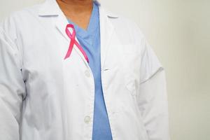 Asian woman doctor with pink ribbon, World Breast Cancer Day at October. photo