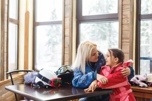 Winter, ski - Little girl with mother in ski resort photo