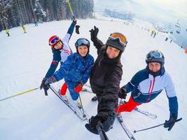 Group of happy skiers and snowboarders stands and smiling photo