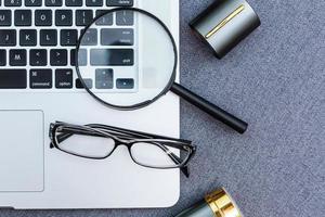 Business summary reports and a magnifying glass with glasses on table office. Concept of Data Analysis, Investment Planning, Business Analytics. photo