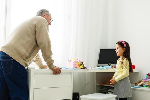 abuelo hablando y sonriendo con su nieta en la mesa foto
