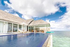 vacaciones y viajes de verano de lujo. hermoso paisaje junto a la piscina y el cielo del atardecer. lujoso paisaje de playa tropical, tumbonas y tumbonas y reflejo de agua. foto