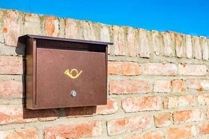 Modern metal mail box on brick stone wall photo