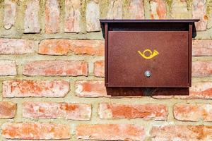 buzón de correo de metal moderno en la pared de piedra de ladrillo foto