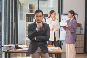 Marketing, Financial, Accounting, Planning, A male businessman standing in front of a business team with a very unhappy expression inside the office. photo