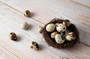 Easter banner with quail eggs in the nest on wooden table. Rustic. photo