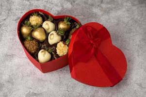 Heart shaped box with assorted chocolate covered strawberries on a gray background.St Valentine's,mother's day concept photo