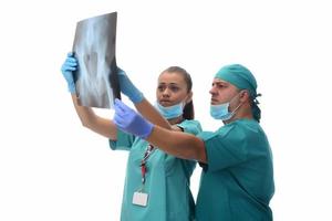radiólogos femeninos y médico masculino revisando la radiografía del paciente. aislado sobre fondo blanco foto