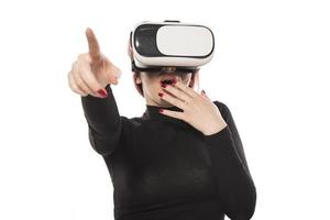 linda mujer emocionada con auriculares vr mirando hacia arriba y tratando de tocar objetos en la realidad virtual foto