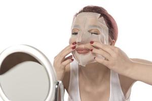 Cosmetic procedure. Woman's face with white cosmetic mask photo