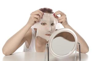 Cosmetic procedure. Woman's face with white cosmetic mask photo