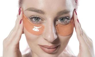 woman with cosmetic patches moisturizing on skin under eyes. isolated on white background photo