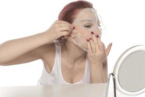 Cosmetic procedure. Woman's face with white cosmetic mask photo