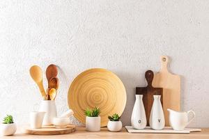 varios utensilios de cocina en una encimera de madera contra el fondo de una pared con textura gris. fondo de cocina para el diseño con un espacio de copia. foto