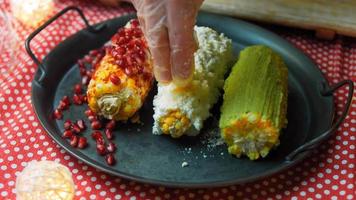 messicano Mais elote nel tre modi. premuto con formaggio, guacamole e Melograno. maxican bandiera video