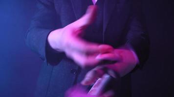 Close-up, Hands of a Magician Performing Tricks with a Deck of Cards. Blue Lighting. Conjurer Shows Focus. Unrecognizable person. video