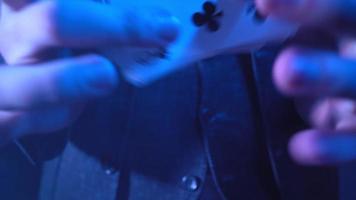 Nahaufnahme, Hände eines Zauberers, der Tricks mit einem Kartenspiel vorführt. blaue Beleuchtung. Beschwörer zeigt Fokus. nicht erkennbarer Mensch. video
