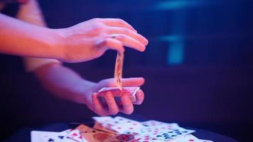 detailopname, handen van een goochelaar het uitvoeren van trucs met een dek van kaarten. blauw verlichting. goochelaar shows focus. camera snel draait 360 graden. video